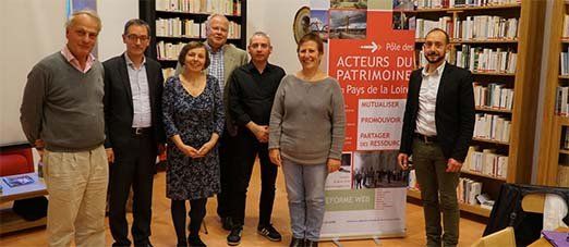 7 représentants du pôle patrimoine devant une bibliothèque